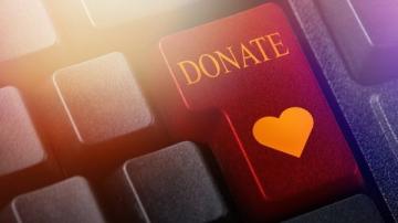 A keyboard with a red button marked with DONATE and a heart in gold