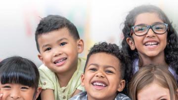Five children smile on the cover of the 28th Annual Conditions of Children Report